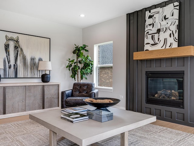 living room featuring a fireplace, recessed lighting, and wood finished floors