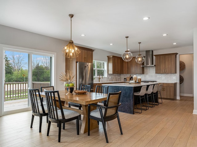 dining area featuring recessed lighting, baseboards, an inviting chandelier, and light wood-type flooring