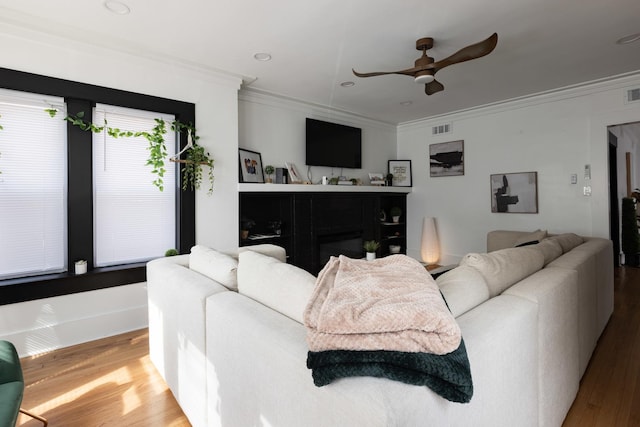 living area featuring ornamental molding, wood finished floors, ceiling fan, and recessed lighting