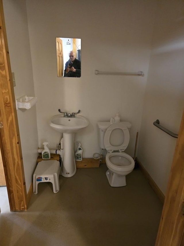 bathroom with toilet and baseboards