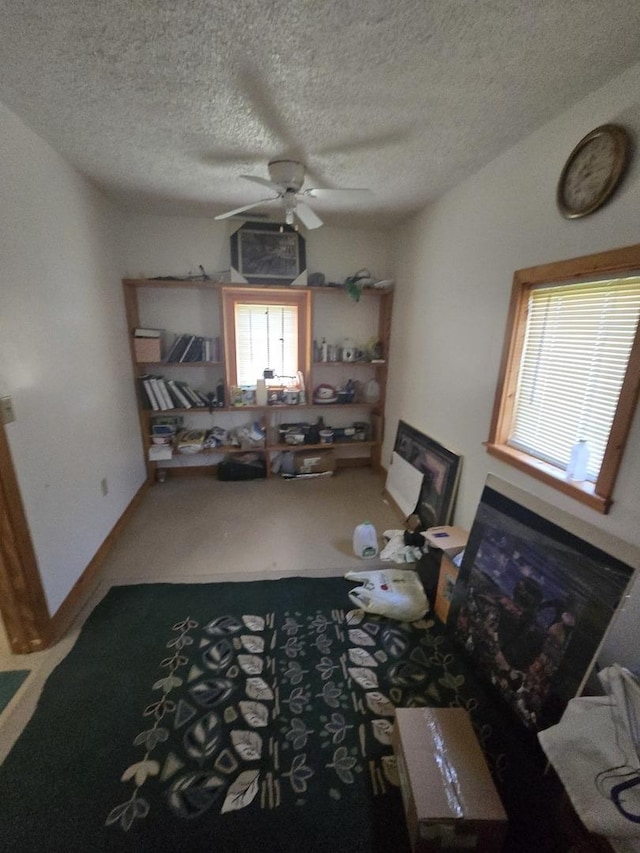 interior space with a textured ceiling and ceiling fan