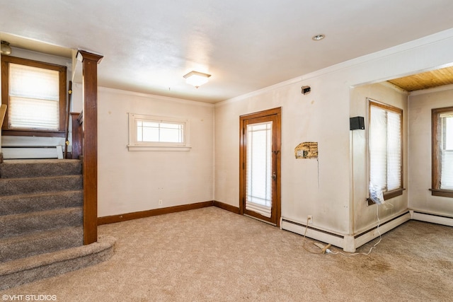 spare room featuring carpet flooring, ornamental molding, a baseboard radiator, baseboard heating, and baseboards