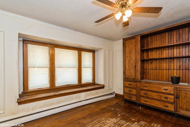 unfurnished room with baseboard heating, dark wood-type flooring, a ceiling fan, ornamental molding, and baseboards