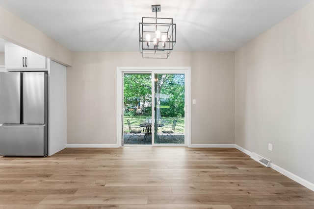 2705 Arlene Dr, Urbana, IL 61802 - unfurnished dining area featuring light wood-style flooring, a chandelier, and baseboards