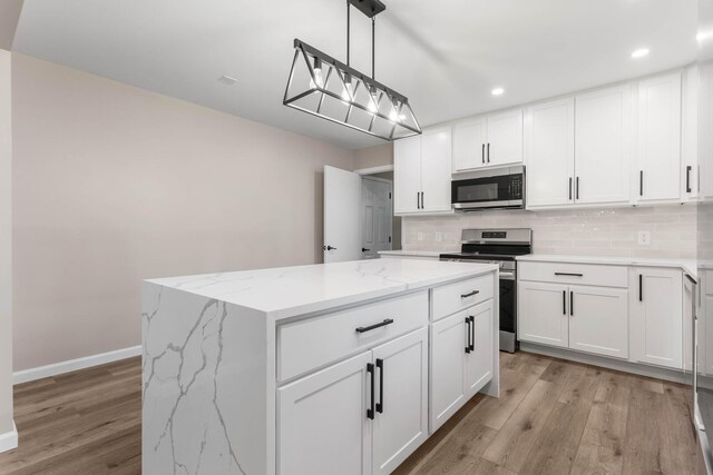2705 Arlene Dr, Urbana, IL 61802 - kitchen with appliances with stainless steel finishes, decorative backsplash, light wood finished floors, recessed lighting, and a kitchen island