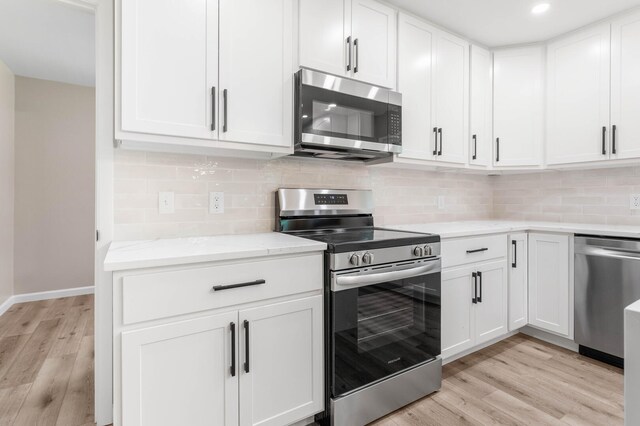 2705 Arlene Dr, Urbana, IL 61802 - kitchen with appliances with stainless steel finishes, light wood-style floors, white cabinetry, decorative backsplash, and recessed lighting