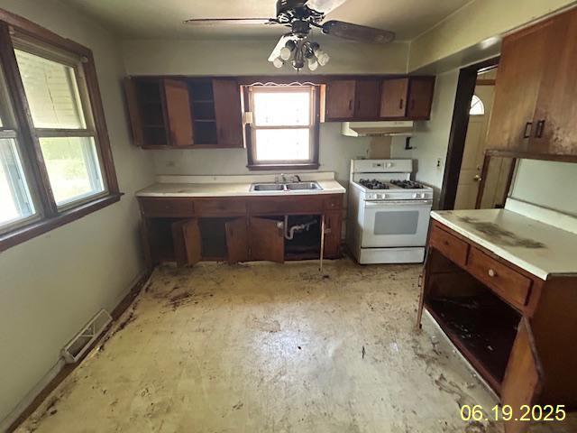 14839 Cooper Ave, Harvey, IL 60426 - kitchen with gas range gas stove, under cabinet range hood, light countertops, and a ceiling fan