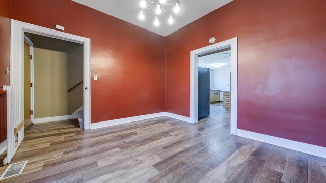 630 Willett Ave, Dixon, IL 61021 - spare room with wood finished floors, baseboards, stairway, and a chandelier
