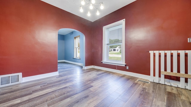 630 Willett Ave, Dixon, IL 61021 - unfurnished room featuring arched walkways, wood finished floors, baseboards, and a chandelier