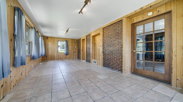 630 Willett Ave, Dixon, IL 61021 - empty room featuring rail lighting, wood walls, and tile patterned floors