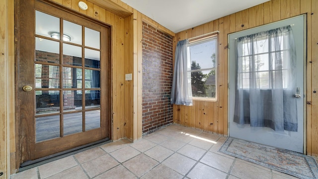 630 Willett Ave, Dixon, IL 61021 - doorway to outside featuring wood walls, light tile patterned floors, and brick wall