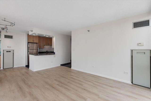 111 W Maple St Unit 3001, Chicago, IL 60610 - unfurnished living room featuring light wood-type flooring, baseboards, and rail lighting