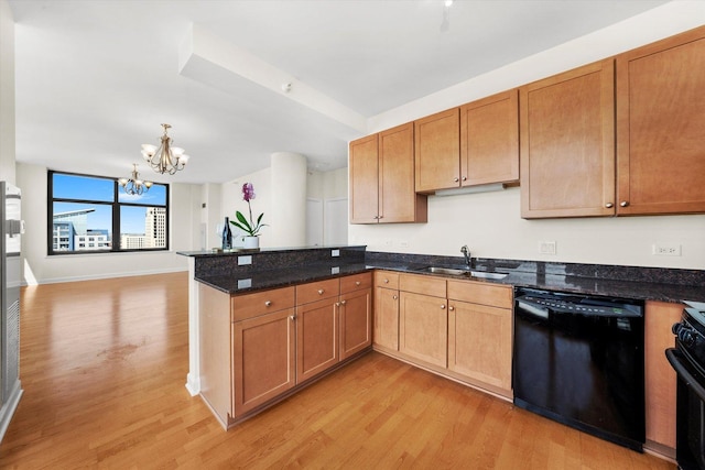 kitchen with black appliances, a sink, a peninsula, a chandelier, and light wood finished floors