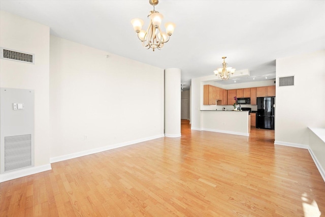 233 E 13th St Unit 2209, Chicago, IL 60605 - unfurnished living room featuring a chandelier, light wood-style flooring, and baseboards