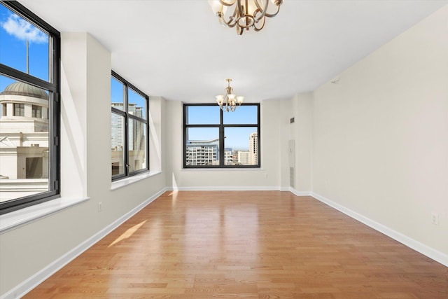 233 E 13th St Unit 2209, Chicago, IL 60605 - unfurnished dining area featuring a chandelier, light wood-style flooring, plenty of natural light, and baseboards
