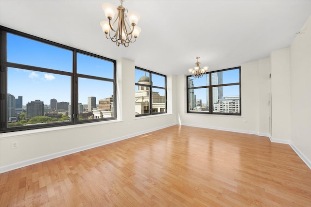 233 E 13th St Unit 2209, Chicago, IL 60605 - spare room featuring a chandelier, light wood-type flooring, baseboards, and a city view