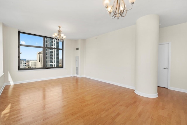 233 E 13th St Unit 2209, Chicago, IL 60605 - spare room featuring a chandelier, light wood-style flooring, and baseboards