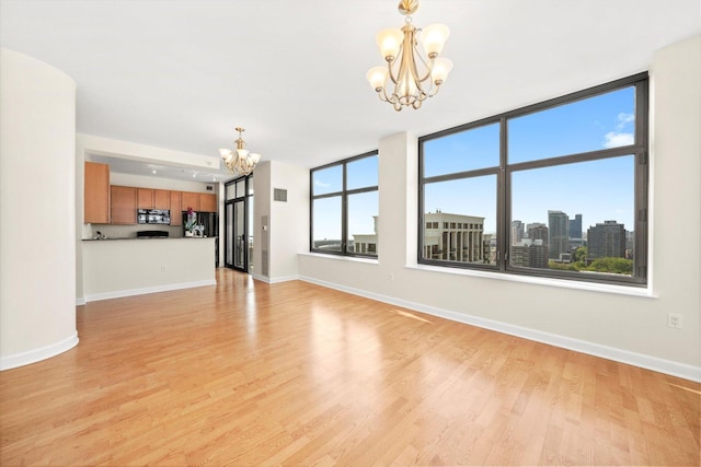233 E 13th St Unit 2209, Chicago, IL 60605 - unfurnished living room featuring a chandelier, light wood finished floors, and baseboards