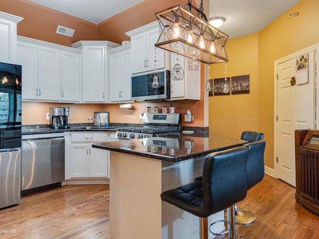 17200 Oak Park Ave Unit R-206, Tinley Park, IL 60477 - kitchen featuring stainless steel appliances, a kitchen bar, light wood-type flooring, and visible vents