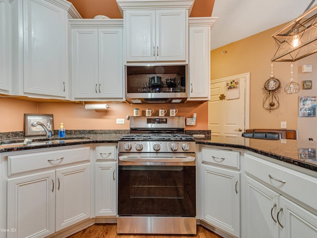 17200 Oak Park Ave Unit R-206, Tinley Park, IL 60477 - kitchen with a sink, dark stone countertops, light wood finished floors, white cabinets, and appliances with stainless steel finishes