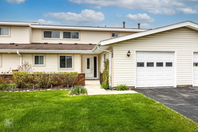 multi unit property with a front yard, asphalt driveway, and roof with shingles