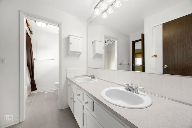 full bath with decorative backsplash, toilet, tile patterned floors, double vanity, and baseboards