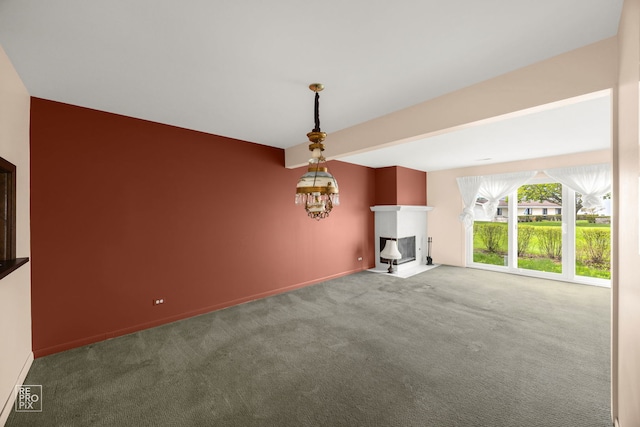 unfurnished living room featuring carpet flooring, a fireplace with flush hearth, and baseboards