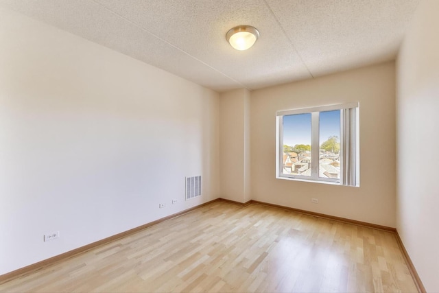 6560 W Diversey Ave Unit 412D, Chicago, IL 60707 - spare room with light wood finished floors, a textured ceiling, and baseboards