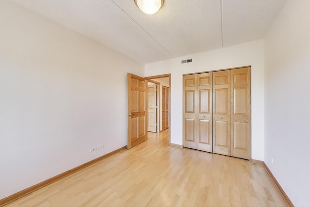 6560 W Diversey Ave Unit 412D, Chicago, IL 60707 - unfurnished bedroom with light wood finished floors, baseboards, and a closet