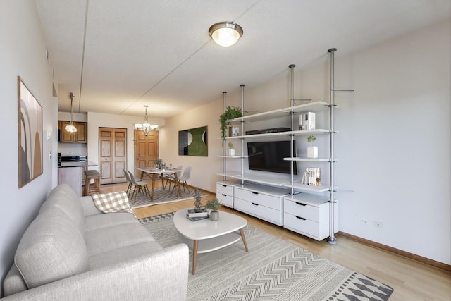 6560 W Diversey Ave Unit 412D, Chicago, IL 60707 - living area featuring light wood-type flooring, a chandelier, and baseboards
