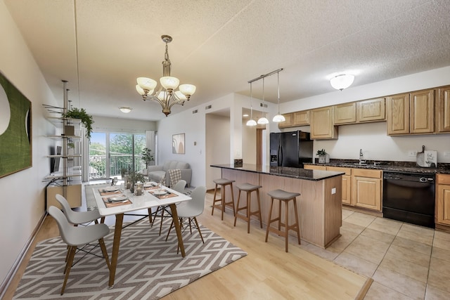 6560 W Diversey Ave Unit 412D, Chicago, IL 60707 - kitchen with black appliances, a chandelier, a breakfast bar, a sink, and pendant lighting