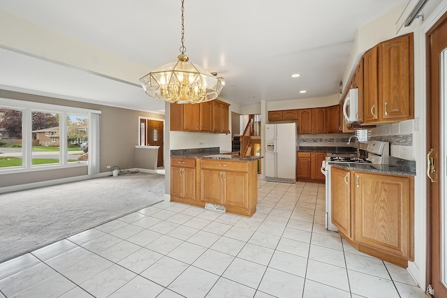 kitchen with white appliances, light colored carpet, light tile patterned flooring, recessed lighting, and a notable chandelier