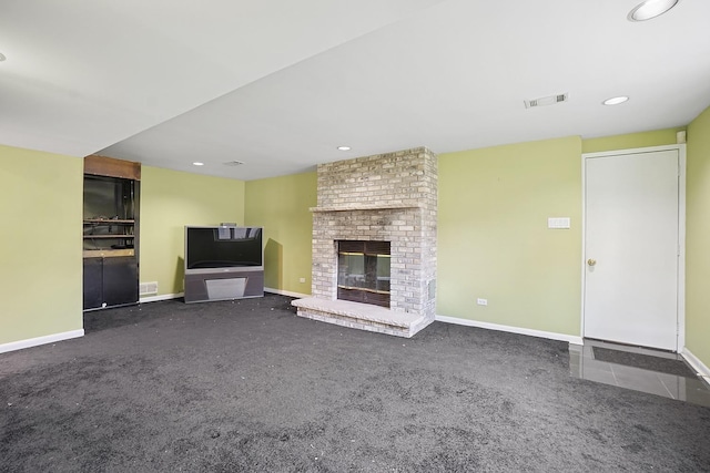 unfurnished living room with a fireplace, carpet floors, baseboards, and visible vents