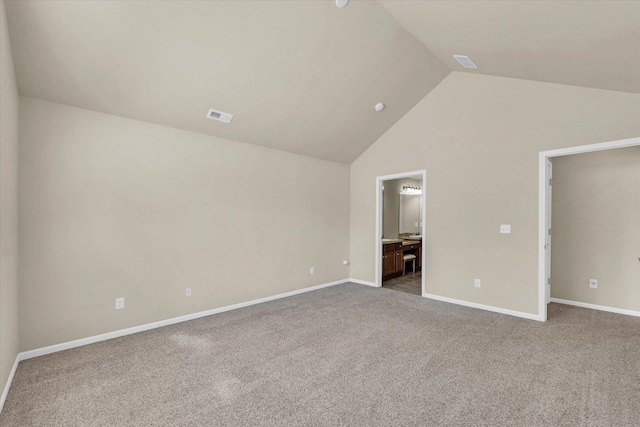 unfurnished bedroom featuring lofted ceiling, carpet, baseboards, and connected bathroom