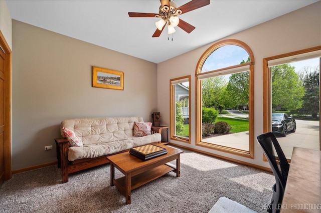 living area featuring carpet, ceiling fan, and baseboards