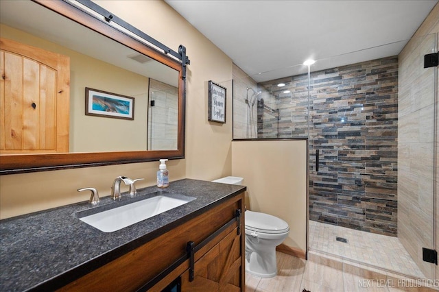 bathroom with tiled shower, toilet, and vanity