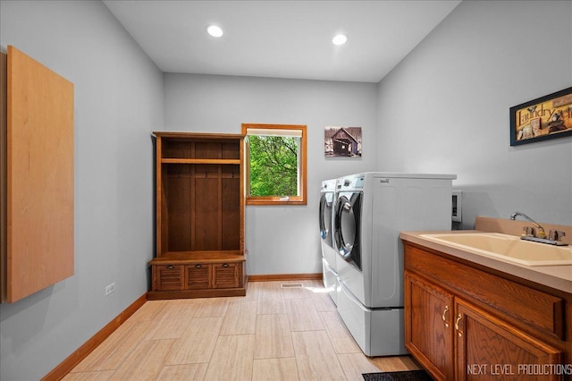 clothes washing area with independent washer and dryer, baseboards, light wood-style floors, and recessed lighting