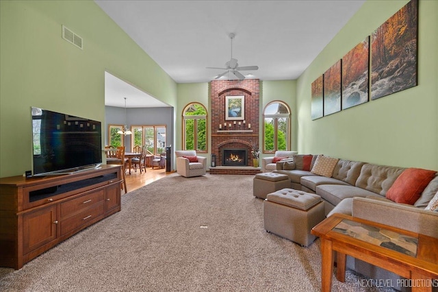 carpeted living area featuring plenty of natural light, a ceiling fan, and a fireplace