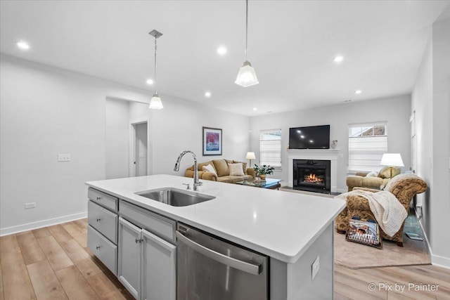 3610 Reddington Cir, Elgin, IL 60124 - kitchen with a sink, stainless steel dishwasher, a glass covered fireplace, and light wood-style floors