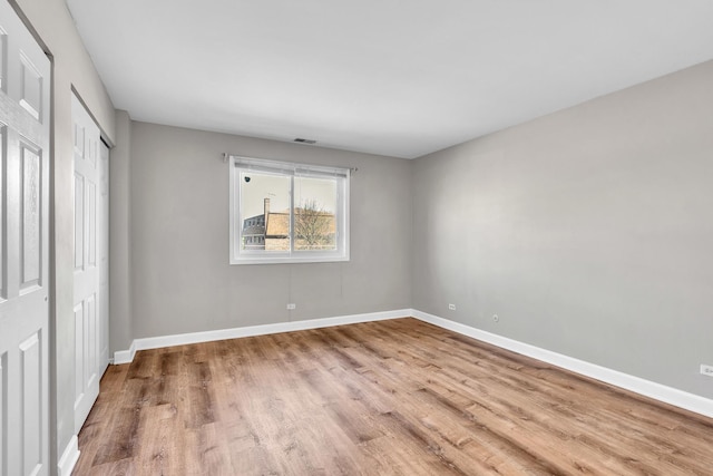 503 Mchenry Rd Unit 2A, Wheeling, IL 60090 - unfurnished bedroom featuring baseboards, a closet, visible vents, and wood finished floors