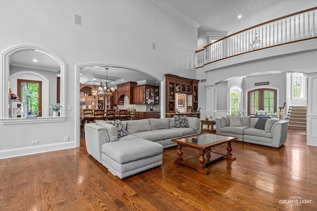 4779 Lees Ct, Oswego, IL 60543 - living room featuring arched walkways, a high ceiling, stairs, wood finished floors, and crown molding