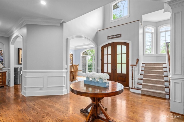 4779 Lees Ct, Oswego, IL 60543 - entrance foyer featuring french doors, wood finished floors, healthy amount of natural light, arched walkways, and ornamental molding
