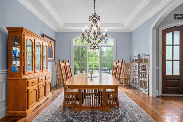 4779 Lees Ct, Oswego, IL 60543 - dining area featuring a chandelier, healthy amount of natural light, arched walkways, ornamental molding, and light wood finished floors