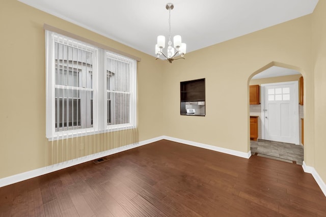 2720 S Christiana Ave, Chicago, IL 60623 - unfurnished room featuring baseboards, visible vents, a chandelier, dark wood-type flooring, and arched walkways
