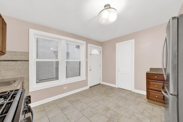 2720 S Christiana Ave, Chicago, IL 60623 - kitchen featuring light countertops, stainless steel appliances, brown cabinets, and baseboards