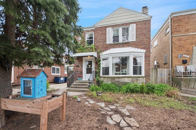 2815 W Jarvis Ave, Chicago, IL 60645 - view of front of home featuring fence, brick siding, and a chimney