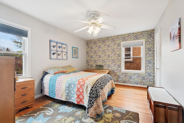 2815 W Jarvis Ave, Chicago, IL 60645 - bedroom with baseboards, wood finished floors, wallpapered walls, and a ceiling fan