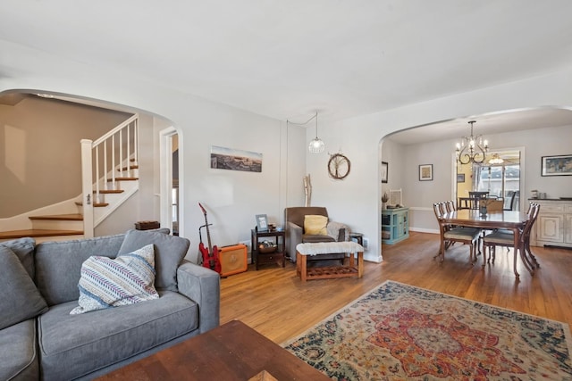 2815 W Jarvis Ave, Chicago, IL 60645 - living room featuring arched walkways, wood finished floors, stairs, and a chandelier