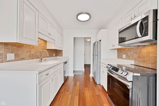 711 S River Rd S Unit 309, Des Plaines, IL 60016 - kitchen with stainless steel appliances, a sink, white cabinets, and light wood finished floors