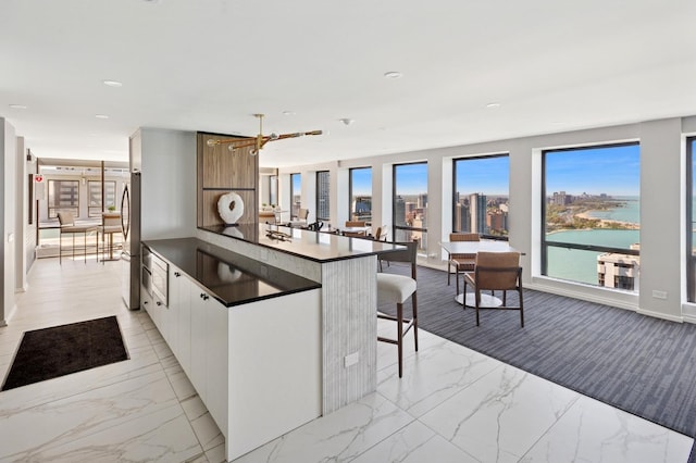 260 E Chestnut St Unit 1706, Chicago, IL 60611 - kitchen with dark countertops, light marble finish flooring, a water view, and recessed lighting